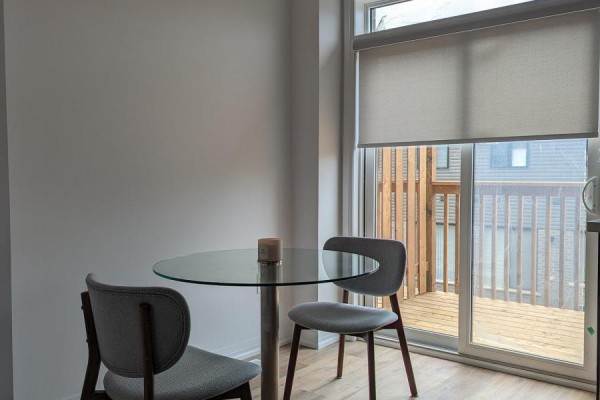 Small glass dining table with two chairs next to sliding glass door to deck. - 70 - 461 Blackburn Drive, Brantford