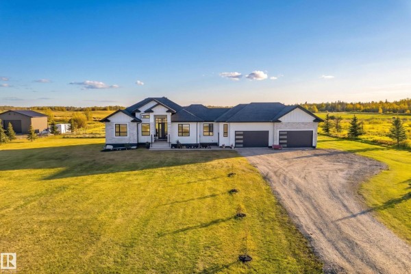 Front exterior of a contemporary white and stone house with a wide driveway. - #70 50509 Rge Rd 222, Rural Leduc County