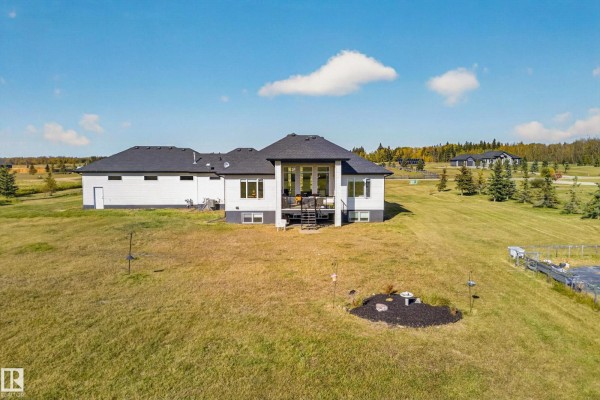 Rear view of the white house showing a walk-out basement and deck. - #70 50509 Rge Rd 222, Rural Leduc County