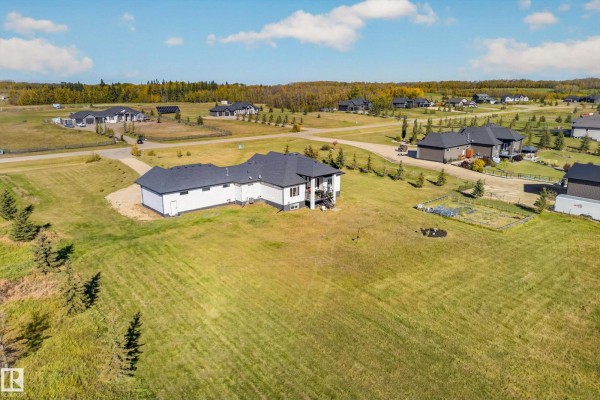 Aerial drone shot of the house and surrounding rural acreage with other homes. - #70 50509 Rge Rd 222, Rural Leduc County