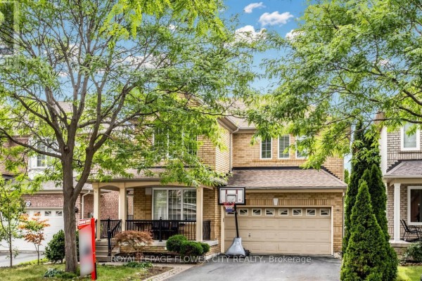 Front exterior of a two-story brick house with a covered porch and garage, showing a basketball hoop. - 70 Boom Road, Vaughan