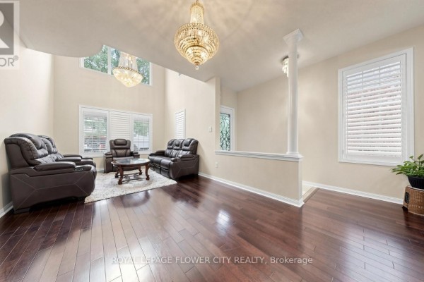 Living room with dark leather sofas, a coffee table, plush rug, and high ceilings. - 70 Boom Road, Vaughan