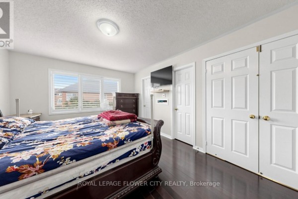 Bedroom with dark hardwood floors, sleigh bed, and wall-mounted TV - 70 Boom Road Vaughan