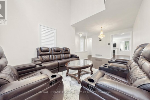 Living room with leather sofas, coffee table, and view into an adjacent dining area. - 70 Boom Road, Vaughan