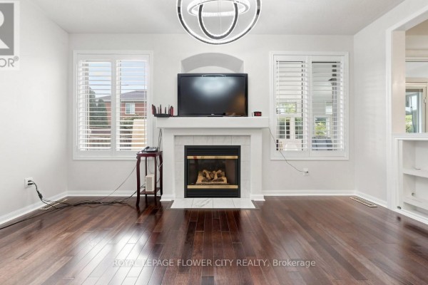 Living room with fireplace, TV, and hardwood floors - 70 Boom Road Vaughan