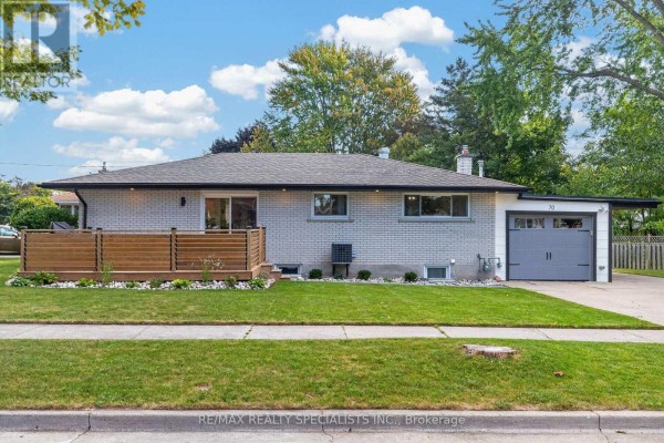 Exterior side view of the house with a deck and attached garage. - 70 Duncairn Avenue, Kitchener