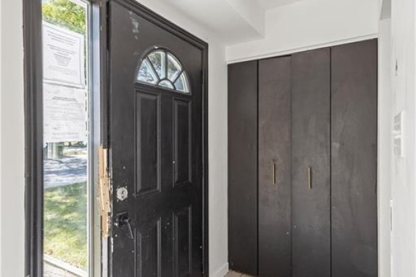 View of the open front door revealing a black door with a circular transom and dark closet doors. - 70 Fiddlers Green Road Unit# 74, London