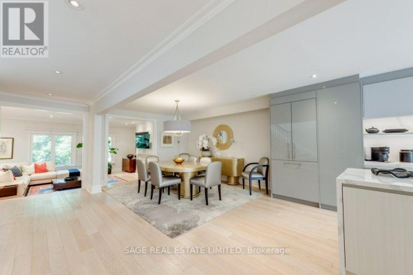Formal dining area with large table, chairs, and adjacent living room. - 70 Heath Street E, Toronto