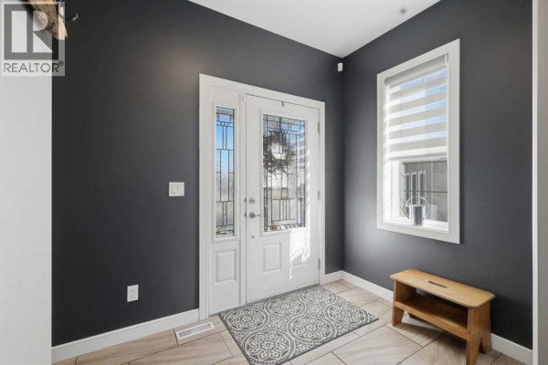 Interior view of a dark gray foyer with a double glass door entrance and a window with blinds. - 70 Mitchell Crescent, Blackfalds