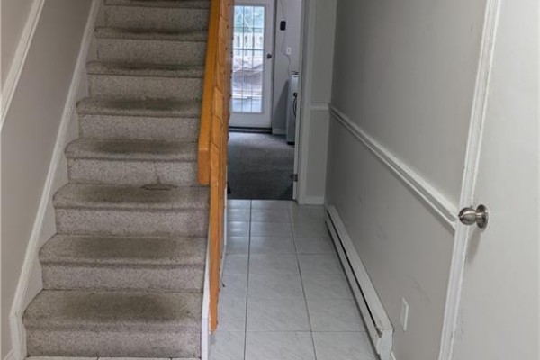 Staircase with grey carpet and wood banister leading down to tiled floor. - 70 Morgan Avenue Unit# 15, Kitchener