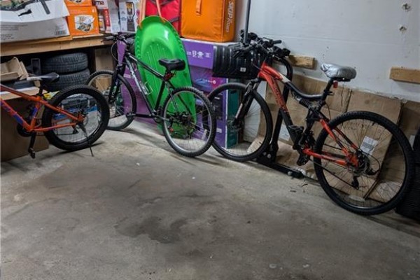 Bicycles parked inside a cluttered garage with concrete floor. - 70 Morgan Avenue Unit# 15, Kitchener