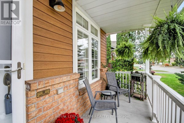 Close-up of the covered front porch with seating and brick and wood detailing. - 70 Sable Run Drive, Ottawa