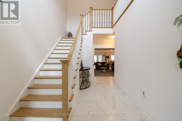 Entrance hall with white marble tile flooring, a light wood staircase with white railings, and a doorway to the living area. - 70 Shipley Avenue, Collingwood