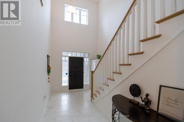 Entrance hall with white marble tile flooring, a black front door with sidelights, and a white staircase with light wood railings. - 70 Shipley Avenue, Collingwood