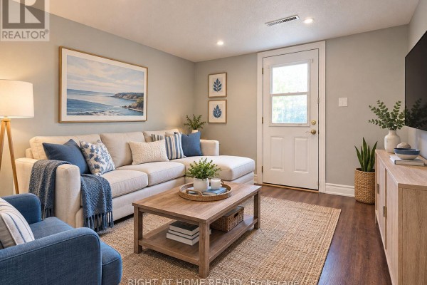 Living room with a sectional sofa, coffee table, and a door leading outside. - 70 Spire Hillway Way, Toronto
