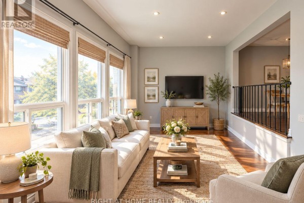 Living room with large windows, a sofa, coffee table, and a television. - 70 Spire Hillway Way, Toronto
