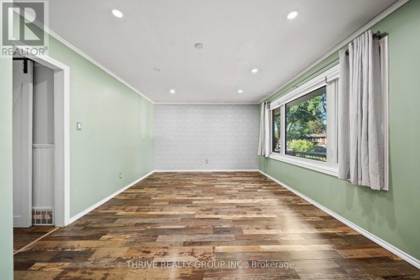 Side view of the house showing the landscaped yard and driveway. - 70 Talavera Crescent, London East