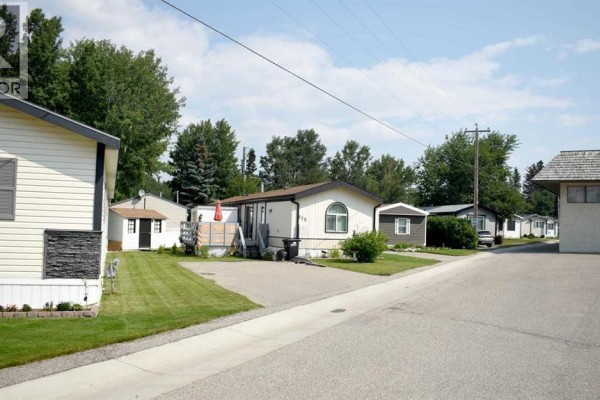 A row of mobile homes with driveways and surrounding trees. - 700 Carmichael Lane, Hinton