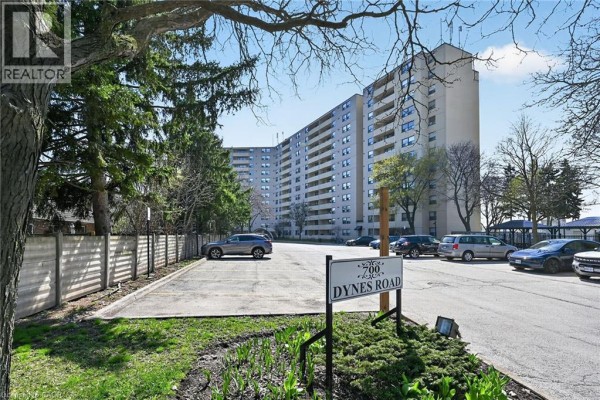 Parking lot and street view of the apartment building entrance at 700 Dynes Road. - 700 Dynes Road Unit# 904, Burlington