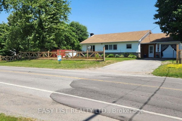 Front and side view of a white house with a driveway and an attached garage. - 700 Norfolk County Road 28, Norfolk