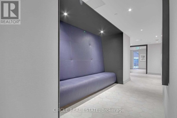 Hallway seating nook with a purple cushioned bench and modern light fixtures. - 701 - 1 Cardiff Road, Toronto