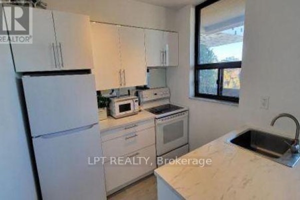 White kitchen with white cabinets, refrigerator, stove, microwave, and a marble-look countertop. - 701 - 105 Mccaul Street, Toronto