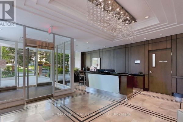 Building lobby with polished marble floors, dark wood paneling, and a reception desk. - 701 - 17 Ruddington Drive, Toronto