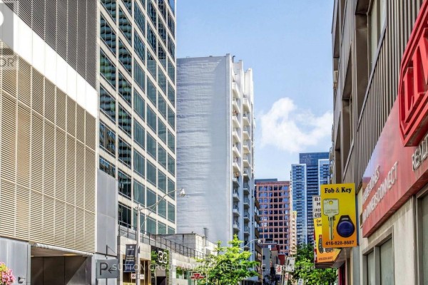 Street view looking up at tall modern buildings on both sides. - 701 - 30 Hayden Street, Toronto