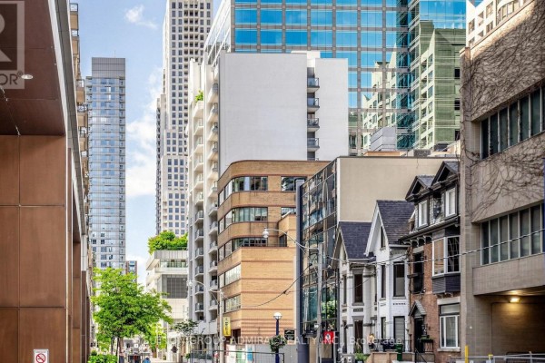 View of street with various building styles, including modern glass and older homes. - 701 - 30 Hayden Street, Toronto