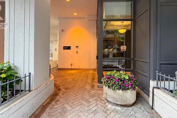 Close-up of condo entrance with herringbone brick floor and potted plants. - 701 - 30 Hayden Street, Toronto