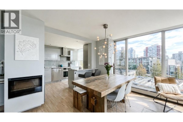 Building lobby with wood paneling, large concrete columns, modern chairs, and an elevator. - 701 120 W 2nd Street, North Vancouver