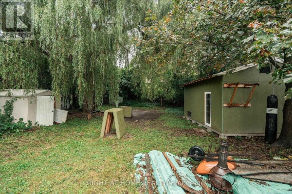 Yard with shed, punching bag, wheelbarrow, and weeping willow tree - 701 Central Park Boulevard N Oshawa