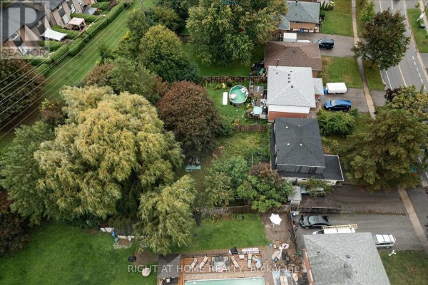 Backyard with above-ground pool, deck, trees, and cars - 701 Central Park Boulevard N Oshawa