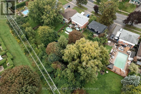 Backyard with pool and deck, surrounded by trees, aerial view - 701 Central Park Boulevard N Oshawa