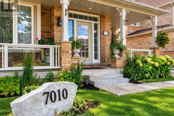 Close-up view of the front entrance, porch steps, and house number sign for 7010. - 7010 Gooderham Estate Boulevard, Mississauga