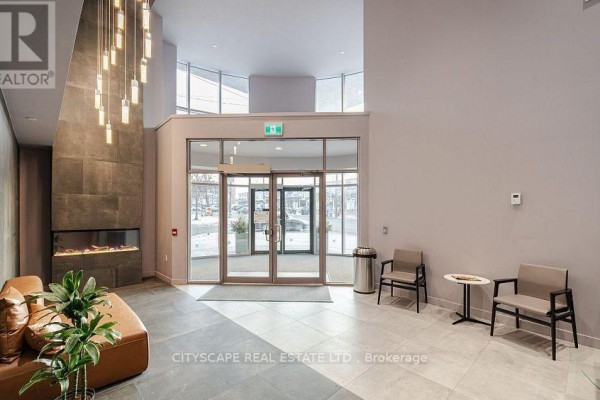 Bathroom with a toilet and a glass-enclosed shower with tiled walls. - 702 - 2433 Dufferin Street, Toronto