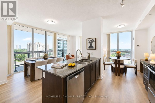 Open-concept living and dining area with large windows, a kitchen island, and city views. - 702 - 3975 Grand Park Drive, Mississauga