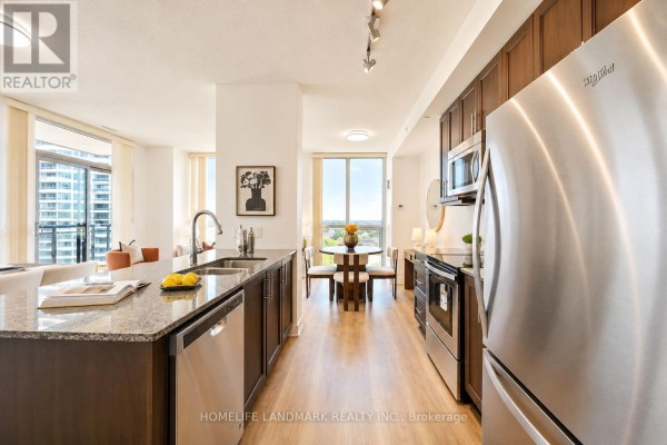 A modern kitchen with dark wood cabinets, stainless steel appliances, and granite countertops. - 702 - 3975 Grand Park Drive, Mississauga