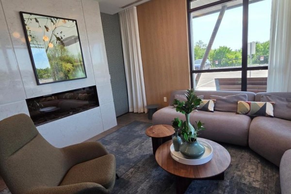 Long, carpeted apartment hallway with neutral walls, doors on either side, and overhead lighting. - 702 - 740 Whitlock Avenue, Milton