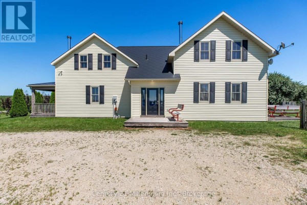 Rear exterior of the cream-colored farmhouse with a double-door entrance and black shutters. - 702174 Sideroad 5, Chatsworth