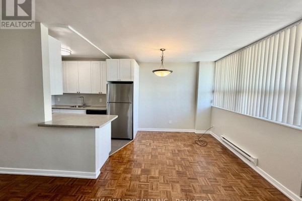 Dining area with parquet flooring and a breakfast bar looking into the kitchen. - 703 - 1209 Richmond Street, London East
