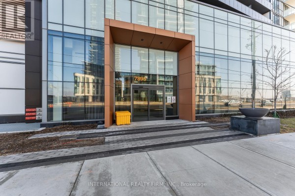 Glass entrance doors with "7895" signage, flanked by metal accents and paving stones. - 703 - 7895 Jane Street, Vaughan