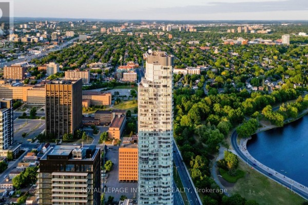Aerial view of a tall curved glass apartment building with Ottawa skyline. - 703 - 805 Carling Avenue, Ottawa
