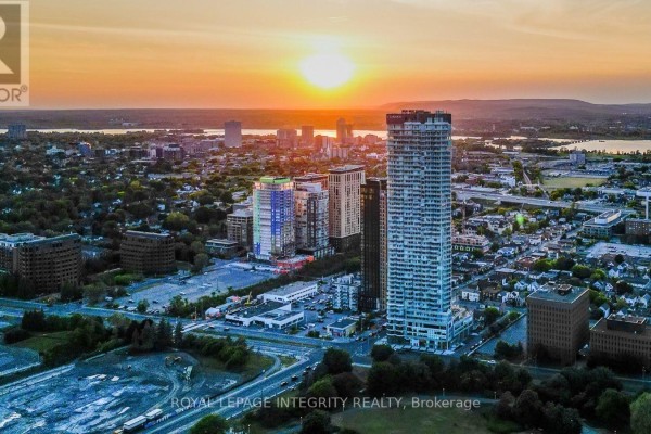 Aerial view of apartment building and surrounding city at sunset. - 703 - 805 Carling Avenue, Ottawa