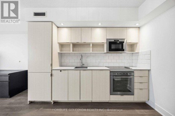 Bathroom features a glass-enclosed shower stall, white toilet, and a light wood vanity with a white countertop. - 703 - 89 Mcgill Street, Toronto