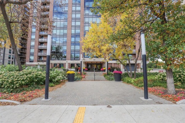 Paved walkway leading to the entrance of a brick apartment building. - 703 141 Wellington Crescent, Winnipeg