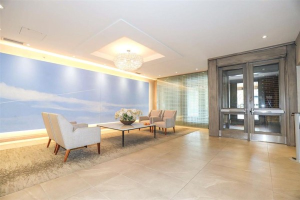 Building lobby with beige tile floors, modern furniture, and decorative wall mural. - 703 141 Wellington Crescent, Winnipeg
