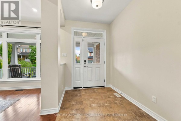 Interior view of the foyer with double doors, light beige walls, and tiled floor. - 703 Mashkig Avenue E, Ottawa