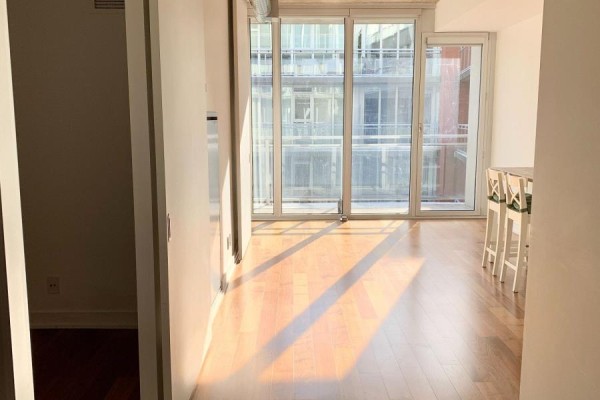 Interior view of an apartment living area with large windows and wood floors. - 704 - 354 Gladstone Avenue, Ottawa