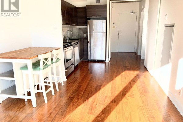 Apartment kitchen and dining area with stainless steel appliances and wood floors. - 704 - 354 Gladstone Avenue, Ottawa